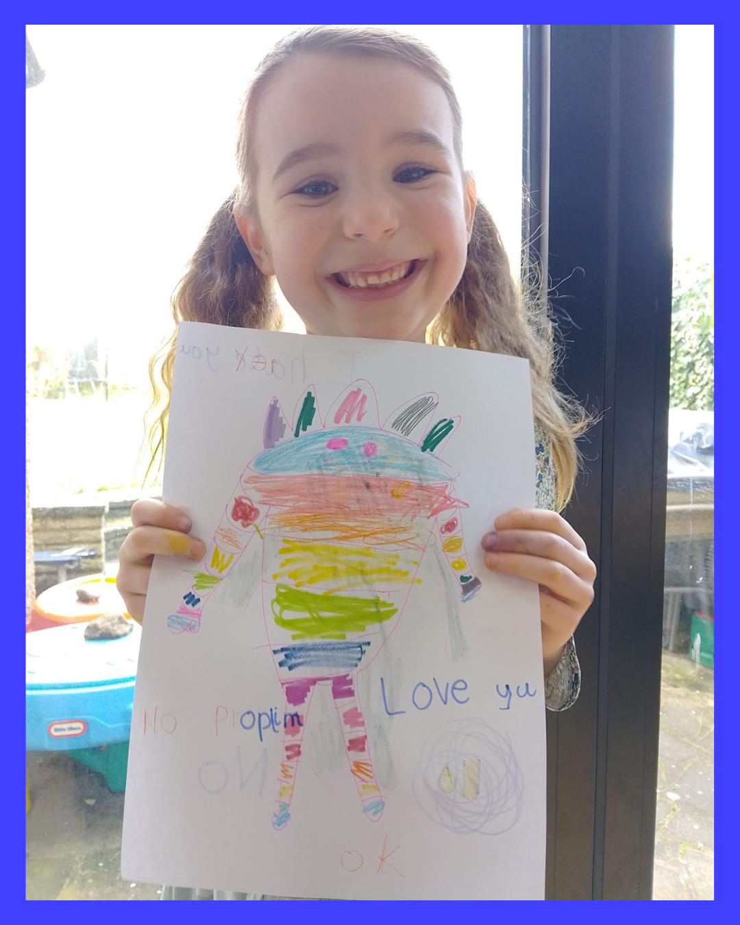 Young girl holding a colorful drawing of Booster
