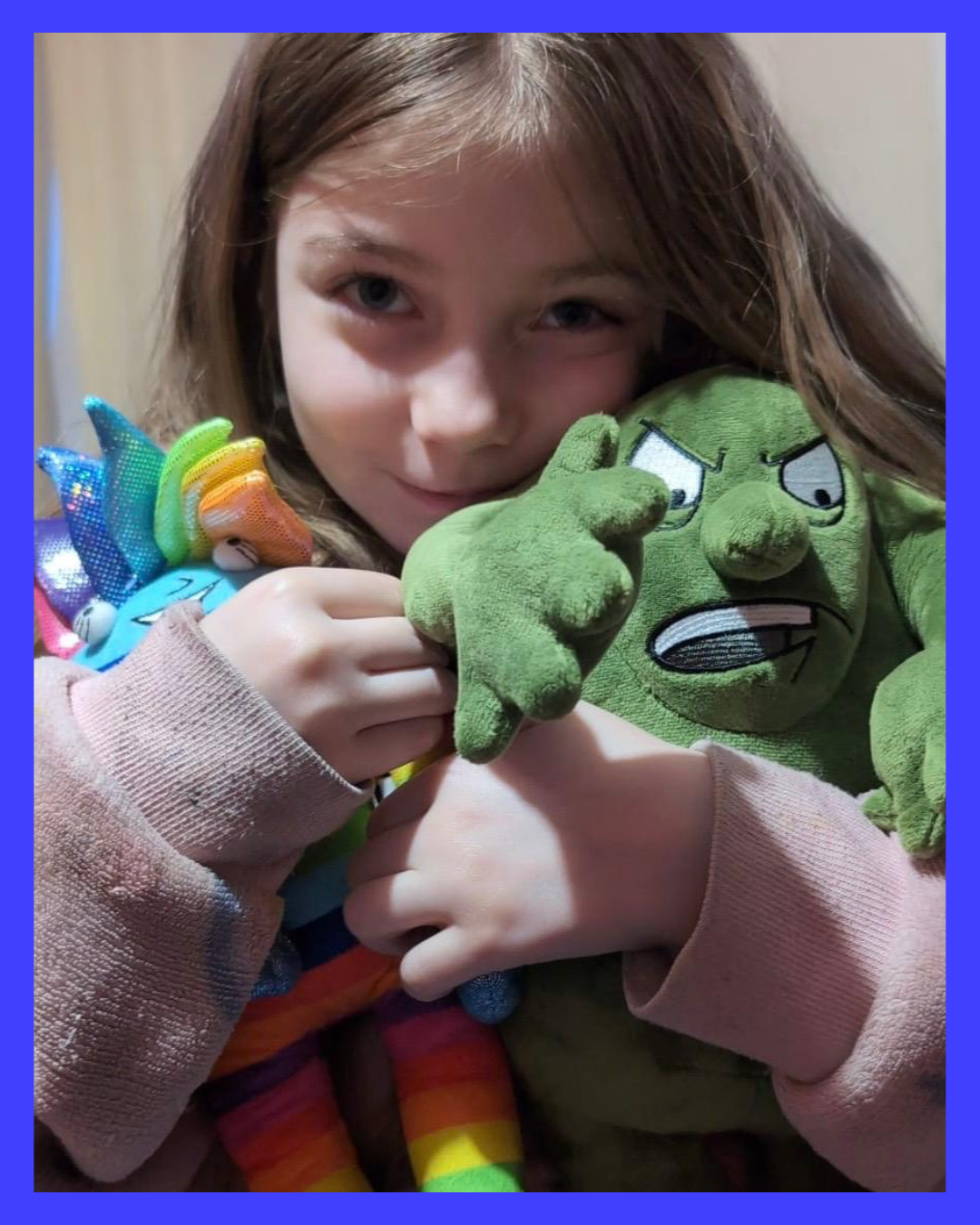 Child holding Booster and  Crusher plush toys